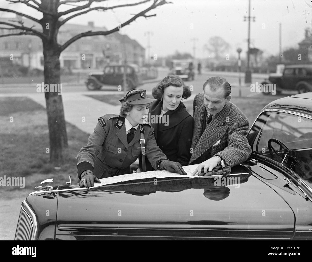 Pour la première fois dans les 45 ans d'histoire de l'automobile Association , des femmes , Mlle Millicent Widdowson de Middlesbrough , Yorkshire , et Mlle Victoria Gardner de Londres , sont employées pour aider directement les membres sur la route : les filles ont été engagées comme chauffeurs pour le A A's London Pilot Service , à travers lequel un visiteur peu familier avec les rues de Londres et les règlements de la circulation peut obtenir un «pilote» expérimenté pour conduire sa voiture à travers la zone métropolitaine encombrée. Les deux recrues féminines portent un uniforme kaki distinctif spécialement conçu. Pendant la guerre, Miss Wid Banque D'Images