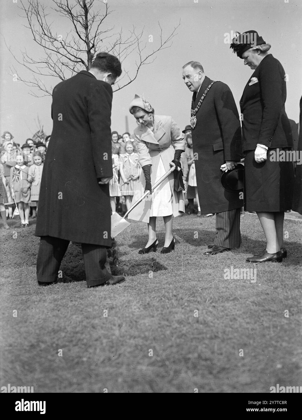 LA PRINCESSE MARGARET PLANTE Un TREE27 mars 1950 la princesse Margaret plante un hêtre de cuivre après avoir ouvert les nouveaux terrains de jeu à Gorton, Manchester, lors de sa tournée de deux jours dans le Lancashire. Avec elle se trouve le maire de Manchester, le conseiller municipal Robert Moss JP Banque D'Images
