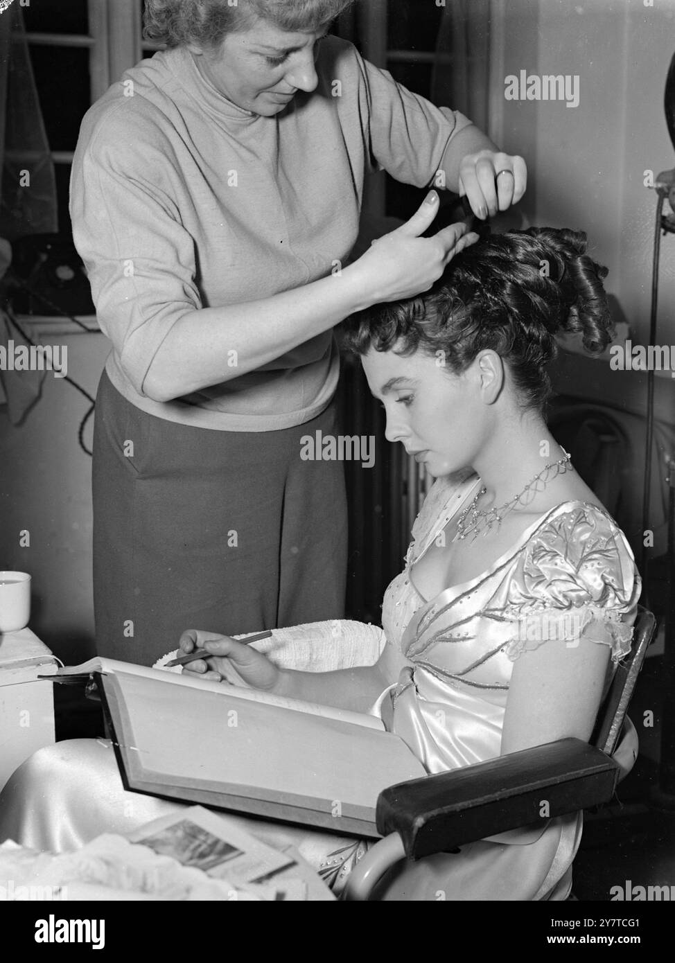 COIFFURE POUR Une NOUVELLE AUTEURE lisant les épreuves de son premier livre (sujet et titre non révélés. Jean Simmons a sa coiffure dans le style d'époque pour son rôle dans le film 'So long at the Fair'. Elle jouera le rôle de Vicky Barton. Le coiffeur est Pearl Gardner. 23 mars 1950 Banque D'Images