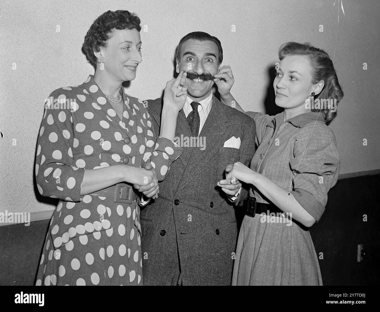 DE NOUVEAUX VISAGES À ' MUCH-BINDING ' Much-binding-in-the Marsh, station gay de radio , ont rouvert leurs portes cet après-midi lorsque les ' Residents ' se sont rassemblés au Cinéma de Paris , Regent Street , Londres . Ils répétaient pour le retour de la série dans le programme Light To-Night de la Colombie-Britannique. Deux nouveaux venus au casting sont Diana Morrison ( elle était Hotch dans l'émission ITMA ) , qui joue deux personnages , et Barbara Leigh , qui est la nouvelle hôtesse du club . IMAGES MONTRENT:-les deux nouvelles filles de ' beaucoup-Binding ' - DIANA MORRISON ( à gauche ) et BARBARA LEIGH - faisant une étude rapprochée de l'un de rad Banque D'Images