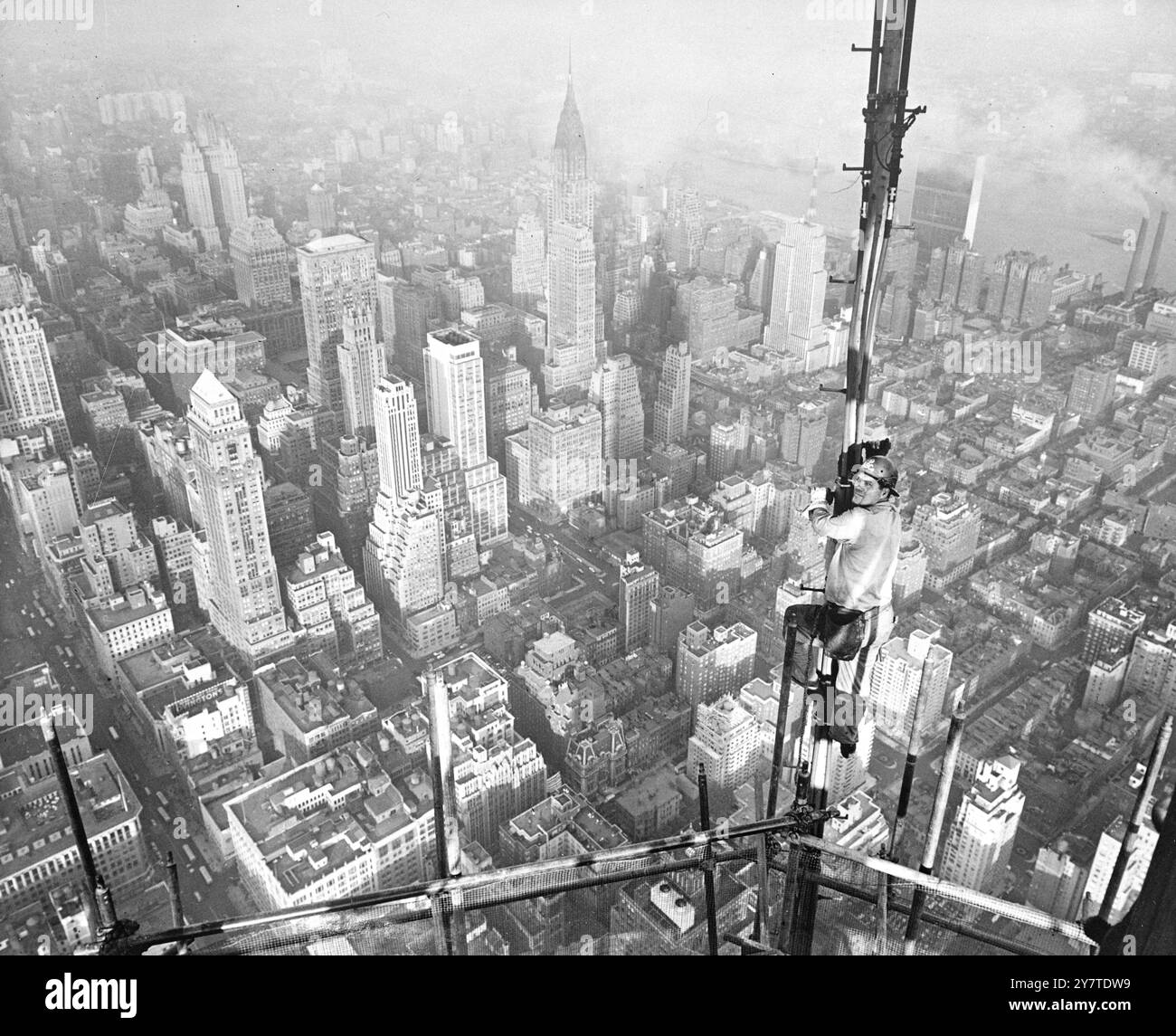 PLUS HAUT QUE LES GRATTE-CIELS ceux dont les nerfs sont assez forts peuvent regarder vers le bas même sur les énormes gratte-ciels de New York. Andrew D. Vernon de Brooklyn, New York bridgeman de l'U.S. Steels American Bridge Company - vu avec la section Midtown de la ville étendue devant lui alors qu'il travaille sur une antenne de télévision temporaire au sommet de l'Empire State Building, le plus haut bâtiment du monde, haut de 1 250 mètres. Vernon est l'un des vingt-deux ouvriers en acier de construction engagés dans l'un des emplois les plus spectaculaires d'érection en acier jamais entrepris - le c Banque D'Images