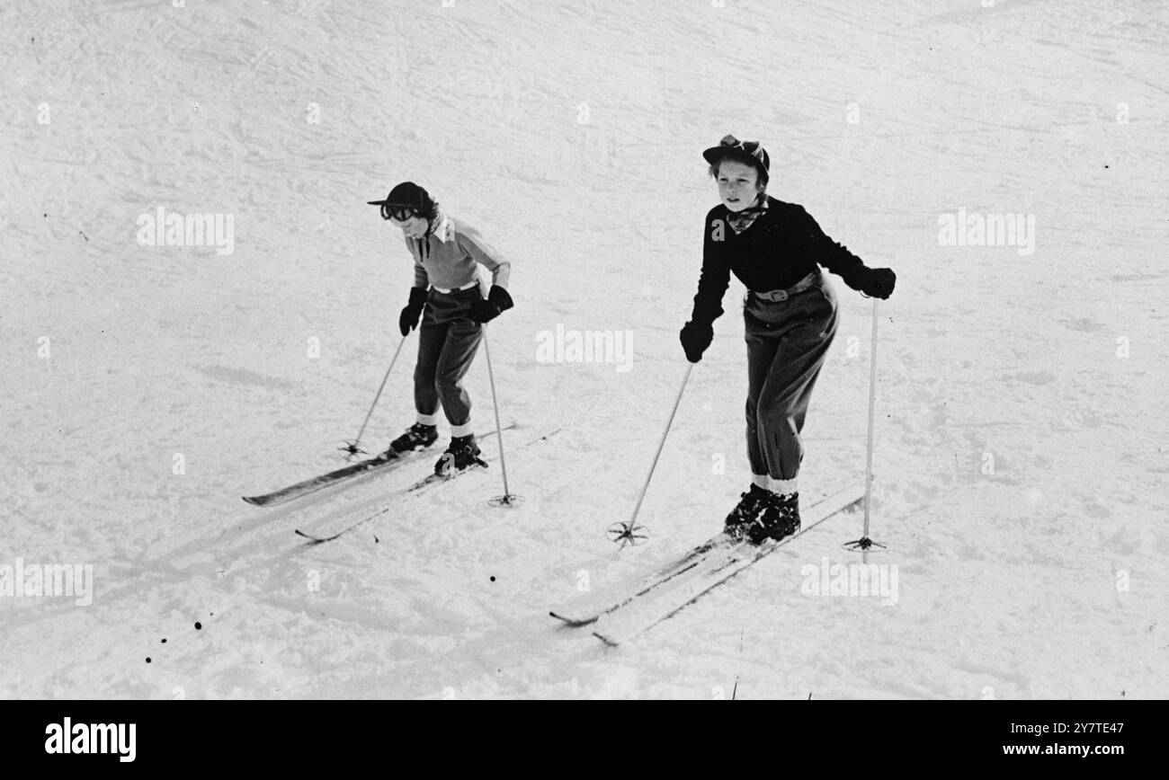 PREMIERS PAS EN SKI-ING ils ont bien fait dans leurs leçons de ski préliminaires, et maintenant les deux princesses hollandaises - Beatrix, 12 ans (à droite) et Irene, 10 1/2, - s'aventurent un peu d'avance sur les pistes de St. Anton, Autriche, où ils passent des vacances avec leur mère et leur sœur, la princesse Magriet. La princesse Beatrix semble assez confiante, mais sa sœur un peu douteuse. 27 février 1950 Banque D'Images