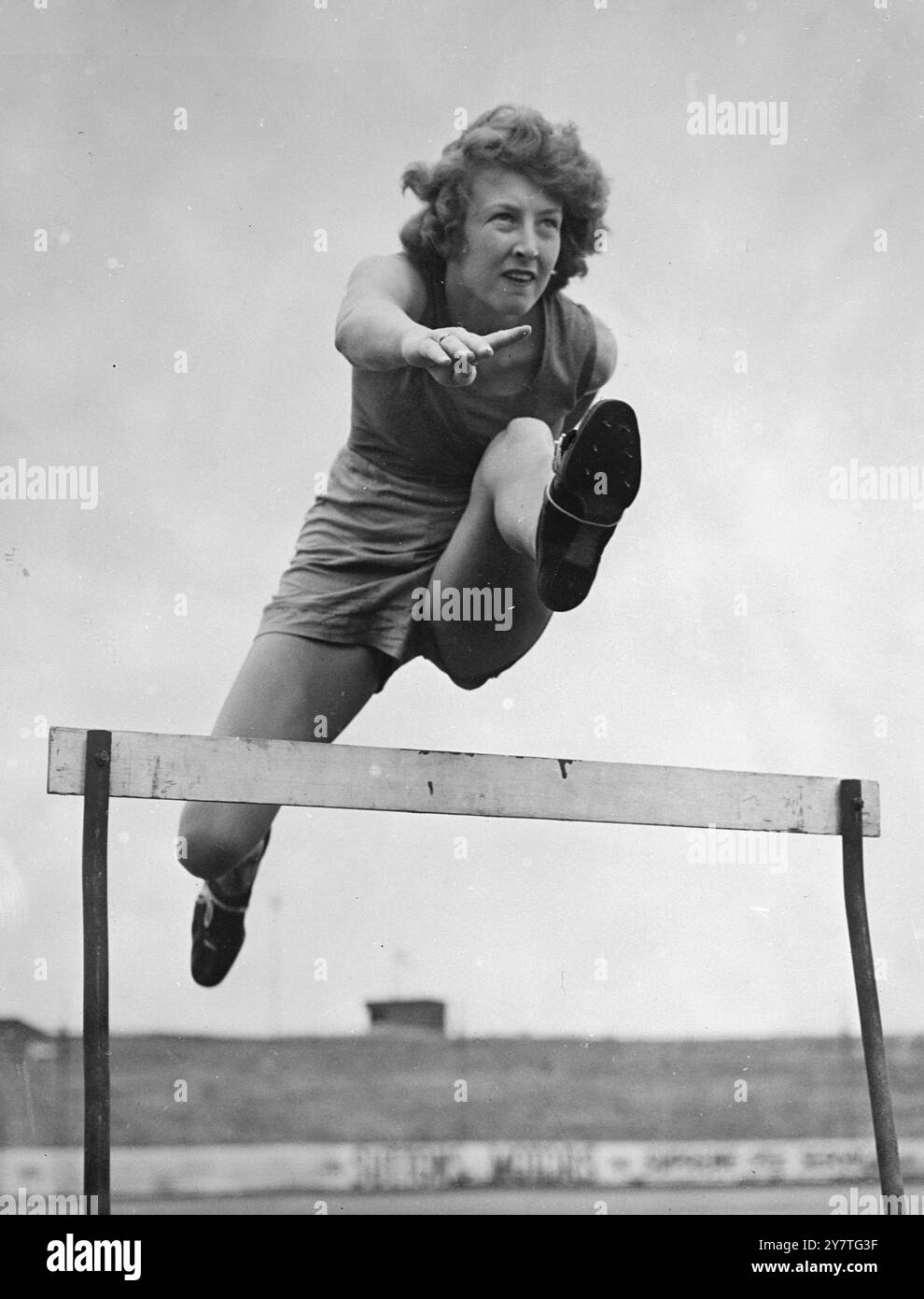 DANS LE MEILLEUR VOL AUSTRALIEN, ANN STADLER, dix-neuf ans, a franchi un obstacle dans sa foulée. Elle est l'une des neuf meilleures athlètes féminines australiennes sélectionnées pour représenter le pays aux Jeux de l'Empire à Auckland, en Nouvelle-Zélande, le mois prochain. Ann, qui est la détentrice du titre de Nouvelle-Galles du Sud, a été finaliste pour le titre australien du 80 mètres haies. 26 janvier 1950 Banque D'Images