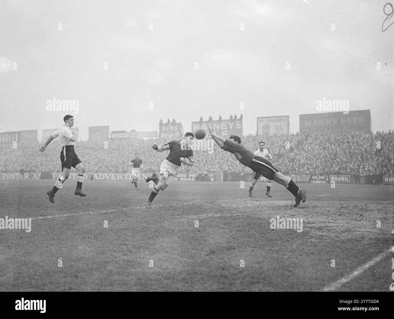 RENCONTRE FRONTALE ' Apex ' du football est Hugh Kelly ( à droite) , le gardien de but Fulham - vu dans ' full-stretch ' dive ' , sauve d'une attaque d'Aston Villa dans le réveillon de Noël premier Division match à Craven Cottage , Londres . 16 novembre 1949 Banque D'Images