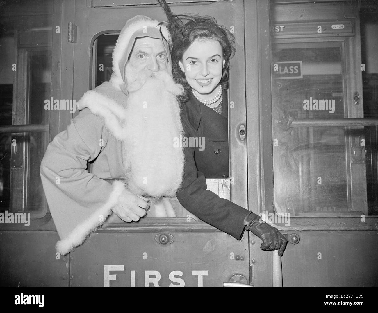 LA BARBE VOYAGE - PÈRE Noël VA EN TRAIN avec un ensemble de jouets pour les enfants de la maison de St Mary, Brighton, Sussex, Père Noël a montré sa perspective progressive en voyageant à Brighton en train électrique (au lieu de par le traîneau traditionnel). Il était accompagné de Patricia Plunkett, actrice de cinéma qui vient de jouer dans le film britannique associé 'Landfall'. À Brighton, le Père Noël, Miss Plunkett et six enfants de la maison devaient faire un trajet cérémoniel de 5 miles à travers la ville dans un autocar-et-quatre. L'entraîneur, celui utilisé dans le film ' Great Expectations ', a participé au Seigneur Banque D'Images