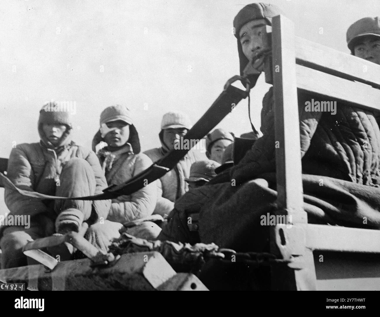 Le visage des Chinois avertis , membres d'un groupe d'environ 200 troupes communistes qui étaient évacuées d'un aérodrome coréen par le combat Cargo Command de l'US Far East Air Force , alors qu'ils sont emmenés par camion jusqu'aux transports de porte-troupes en attente. Beaucoup souffraient de pieds gelés et de hameaux en plus des blessures de combat. Les équipes d'évacuation de l'armée de l'air ont fourni des soins médicaux. 7 janvier 1951 Banque D'Images