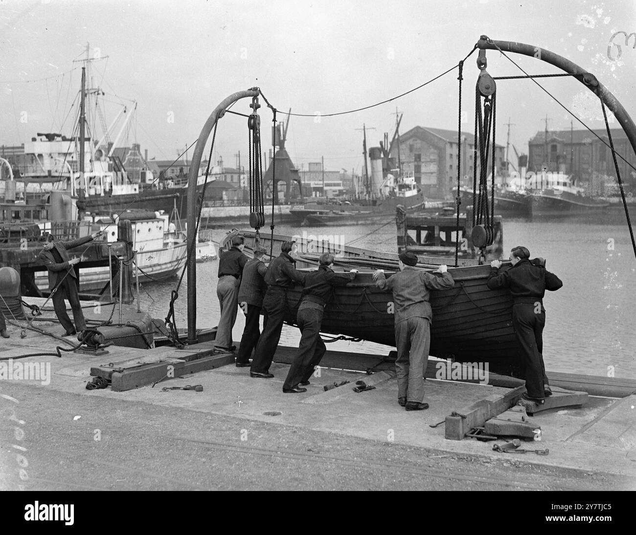 Southampton : les hommes qui poussent le bateau avec beaucoup d'enthousiasme sont de la marine marchande , qui, à l'école nationale de formation maritime, suivent un cours d'une semaine en maniement des canots de sauvetage . Les hommes apprennent à manipuler l'équipement que contient un canot de sauvetage , la navigation en bateau , la lecture de la boussole , et d'autres mesures d'urgence. L'exercice a lieu à partir de davits sur le quai 16 mars 1950 Banque D'Images