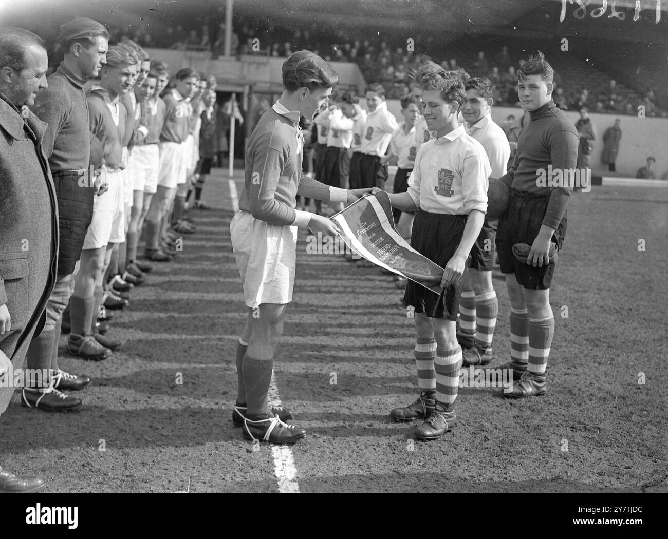 L'équipe English Boys' Club rencontre les jeunes footballeurs allemands Londres : les équipes regardent en tant que capitaine de l'équipe allemande de football jeunesse Kurt Kuschal (Recklinghausen-Sud) , à gauche , serre la main du capitaine anglais , W French ( St Mary and Epsom Boys' Club , Londres), avant le début du match entre l'équipe allemande de la jeunesse et l'équipe nationale des clubs garçons (zone Sud), à l'Arsenal Ground de Highbury. Le match est le premier d'une série de quatre contre les équipes de la National Association of Boys' clubs. L'équipe allemande , de la zone britannique d'Allemagne , a été choisie par le C britannique Banque D'Images