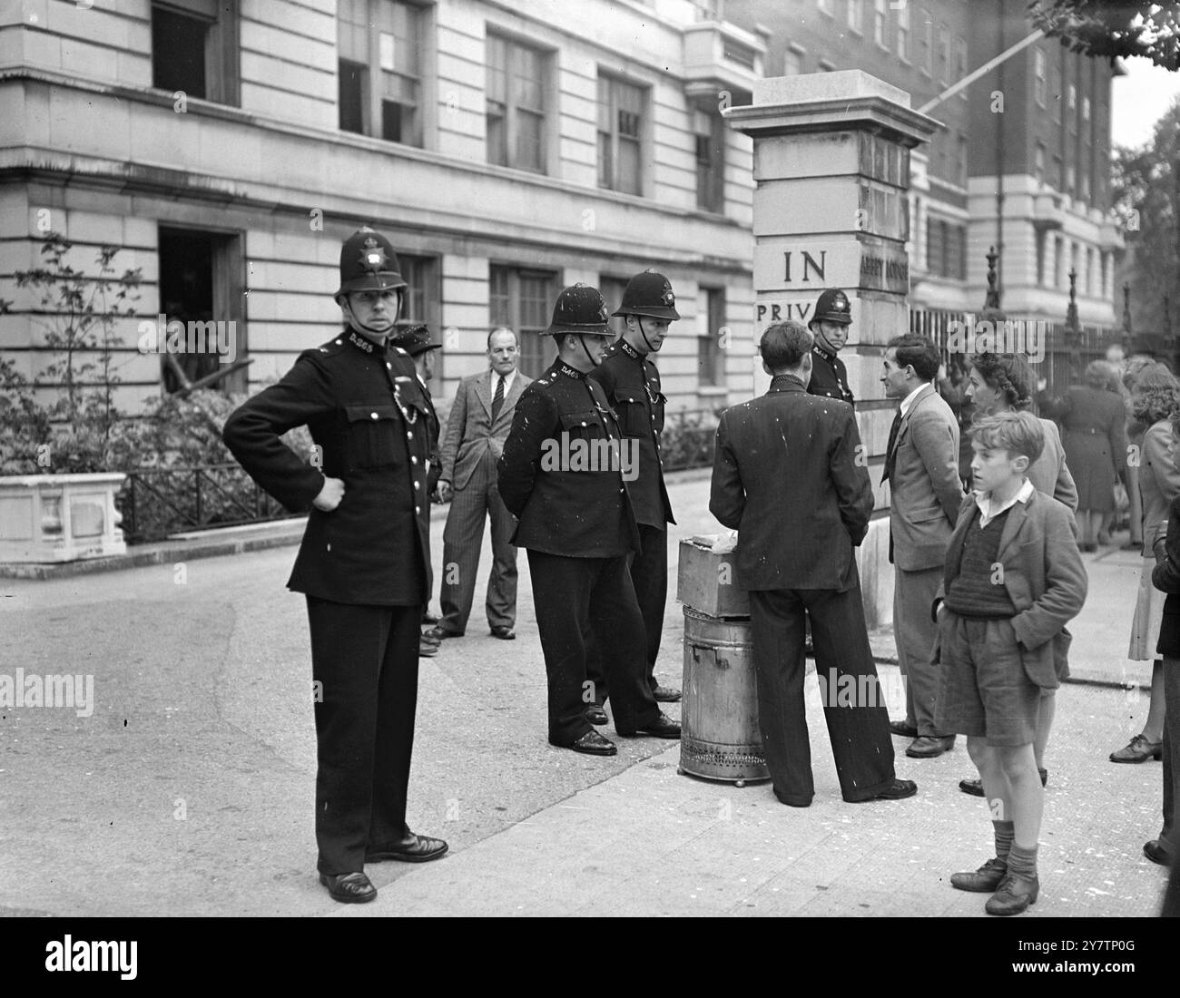 LA POLICE FERME LES APPARTEMENTS LONDONIENS APRÈS UNE NOUVELLE OPÉRATION DE SQUAT. ARRÊTEZ LES LIVRAISONS DE NOURRITURE. La police a isolé environ 30 familles qui ont repris Abbey Lodge, Regent's Park, dans la dernière opération de squat de Londres. Les squatters n'ont ni meubles, ni literie, ni nourriture et la police a refusé de laisser entrer ou sortir quelqu'un du bâtiment. Les hommes chargés de l'enlèvement des meubles ont été empêchés de décharger les meubles et les personnes qui apportaient de la nourriture n'ont pas été autorisées à les livrer. La centaine de personnes dans les appartements comprend un homme de 84 squattant pour sa petite-fille. Photo montre : un policier arrête une livraison ou une urne à thé et une boîte de nourriture à Abbey Lo Banque D'Images