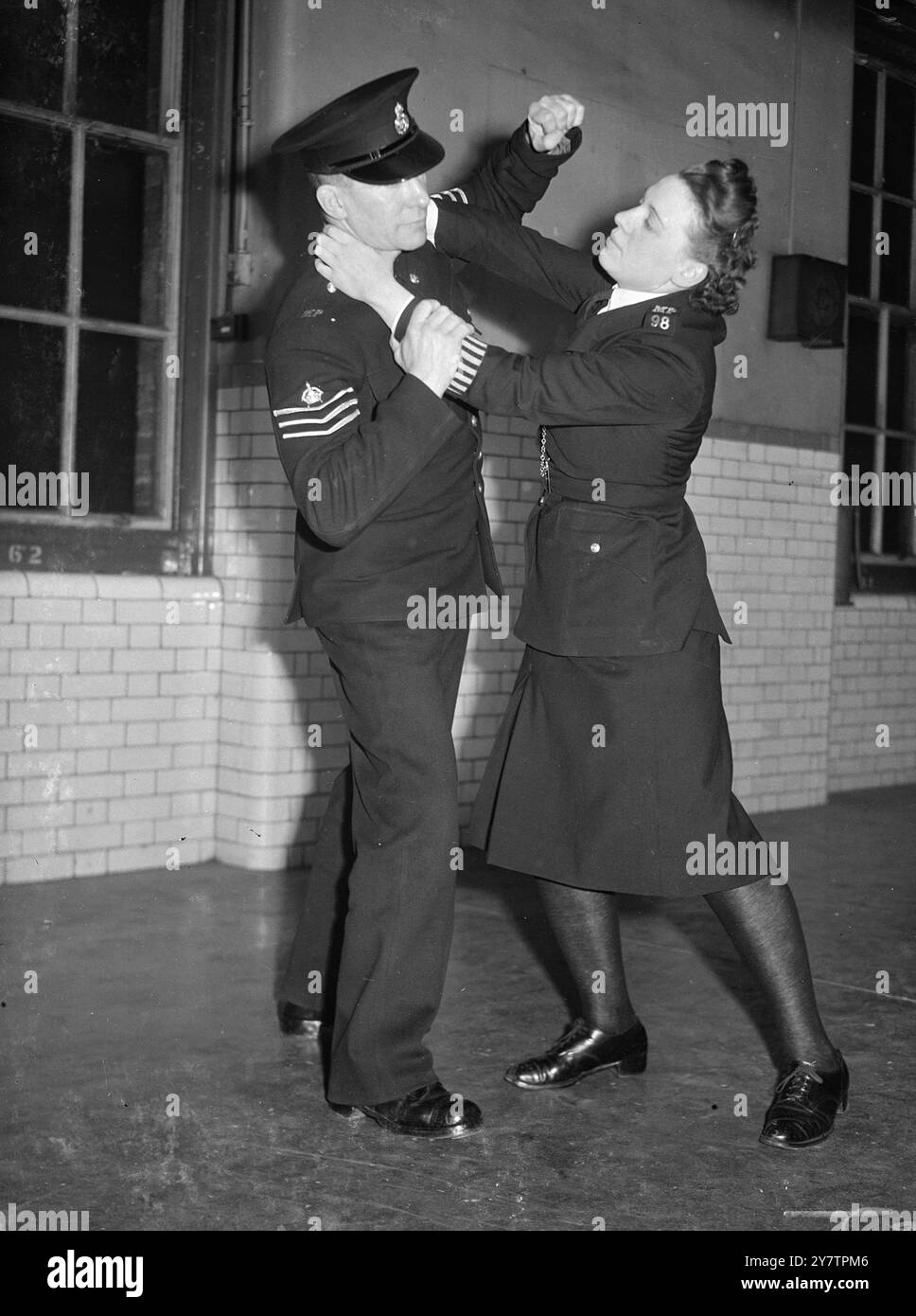La section des femmes de la police métropolitaine formée en 1919 a connu un tel succès qu'un appel à l'expansion est lancé. 150 il faut recruter des policières pour la région de Londres , où leurs tâches consistent principalement à aider et à protéger les femmes et les enfants. Les candidats doivent être célibataires ou veuves, entre 24 et 35 ans et ne pas être moins de 5 pieds 4 in . Ils bénéficient d'une formation de 11 semaines dans des domaines tels que l'administration de la police et l'art de la légitime défense , avant d'être envoyés en battement . Le Sgt S J Bissel montre à une policière comment s'attaquer à une... Banque D'Images