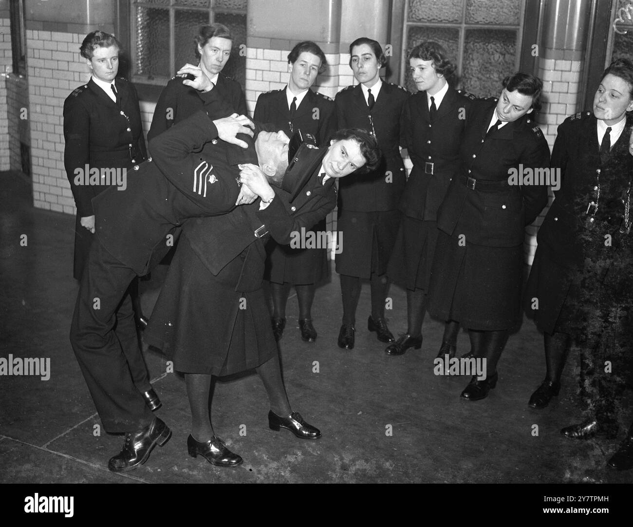 La section des femmes de la police métropolitaine formée en 1919 a connu un tel succès qu'un appel à l'expansion est lancé. 150 il faut recruter des policières pour la région de Londres , où leurs tâches consistent principalement à aider et à protéger les femmes et les enfants. Les candidats doivent être célibataires ou veuves, entre 24 et 35 ans et ne pas être moins de 5 pieds 4 in . Ils bénéficient d'une formation de 11 semaines dans des domaines tels que l'administration de la police et l'art de la légitime défense , avant d'être envoyés en battement . Photos montre : une classe de policières regardent l'un des thei rnumber s'attaquer à l'instruc Banque D'Images