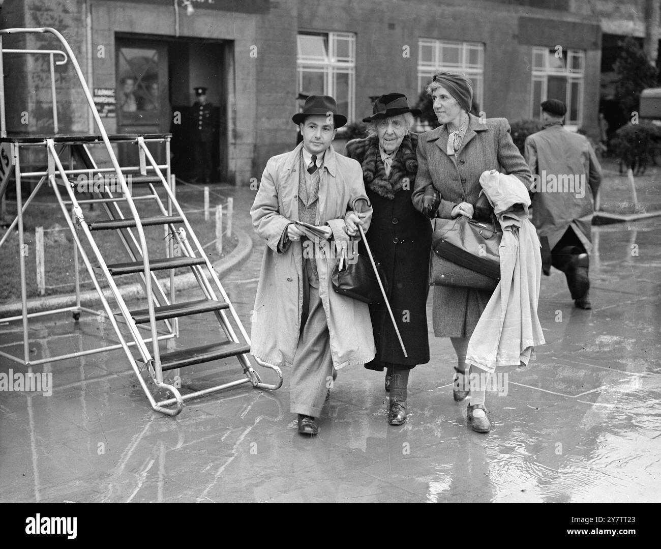 UNE FEMME DE 89 ANS DÉCOLLE À CROYDON POUR LE BRÉSIL Mme H Altmann, femme de 89 ans qui est arrivée en Grande-Bretagne en tant que réfugiée de Cologne, Allemagne, en 1939, a quitté l'aérodrome de Croydon, Londres, sur la première étape d'un voyage aérien vers le Brésil. Mme Altmann va rendre visite à son fils, agriculteur au Brésil, et à sept arrière-petits-enfants. Photo montre : Mme H Altmann (col de fourrure) avec des parents alors qu'elle marchait vers l'avion à Croydon. 29 septembre 1946 Banque D'Images