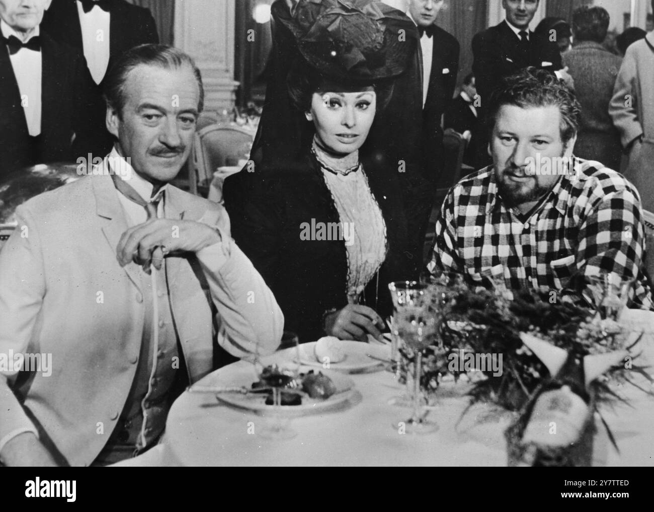 491296 LE LOOK DU XIXE SIÈCLE MONTREUX, SUISSE : LA TOUCHE ROMANTIQUE DES DERNIÈRES ANNÉES DU XIXE SIÈCLE EST ACTUELLEMENT RECRÉÉE EN SUISSE OÙ LE NOUVEAU FILM, LADY L', EST EN COURS DE PRODUCTION. DANS UN DÉCOR DU FILM LORS DU TOURNAGE À MONTREUX RÉCEMMENT SE TROUVENT LES ACTEURS BRITANNIQUES DAVID NIVEN (À GAUCHE), PETER USTINOV ET L'ACTRICE ITALIENNE SOPHIA LOREN, LE 10 JANVIER 1965 Banque D'Images