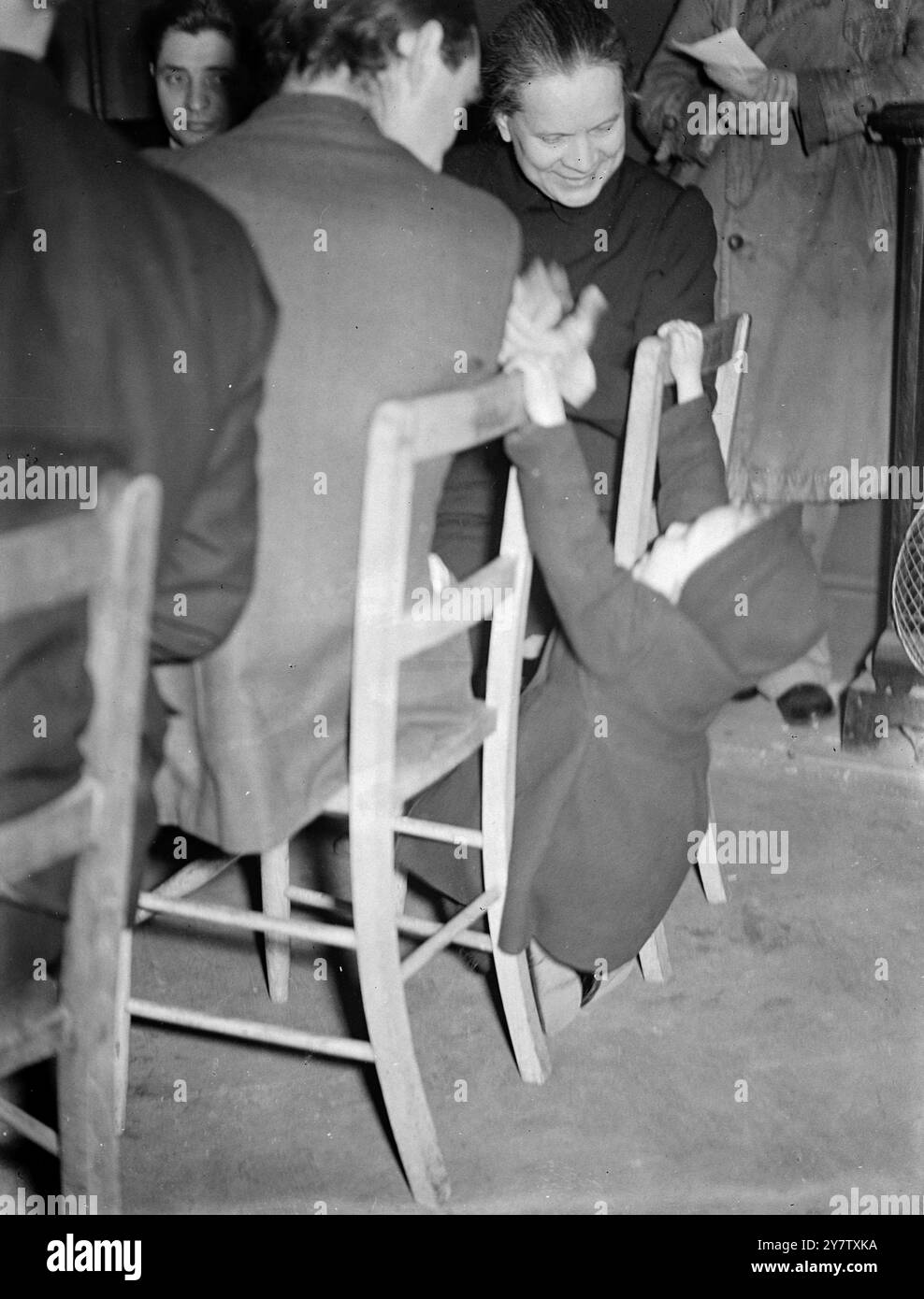 UN ENFANT DE TROIS ANS DIVERTIT LES DÉLÉGUÉES COMMERCIALES SOVIÉTIQUES lors de leur visite des services de la défense civile à Londres les déléguées syndicales soviétiques ont visité un centre de repas londonien (un dépôt d'alimentation communautaire) à Deptford et ont profité d'un déjeuner de tenpenny composé d'une tarte à la viande et de deux légumes, suivi de prunes et de crème anglaise. Shirley Morris, âgée de trois ans et demi, a fait des tours acrobatiques sur des chaises, puis est montée dans les bras de Madame A S Malkova, l'une des déléguées soviétiques. Bien que incapable de parler la même langue l'appel universel des bébés à la femme Banque D'Images