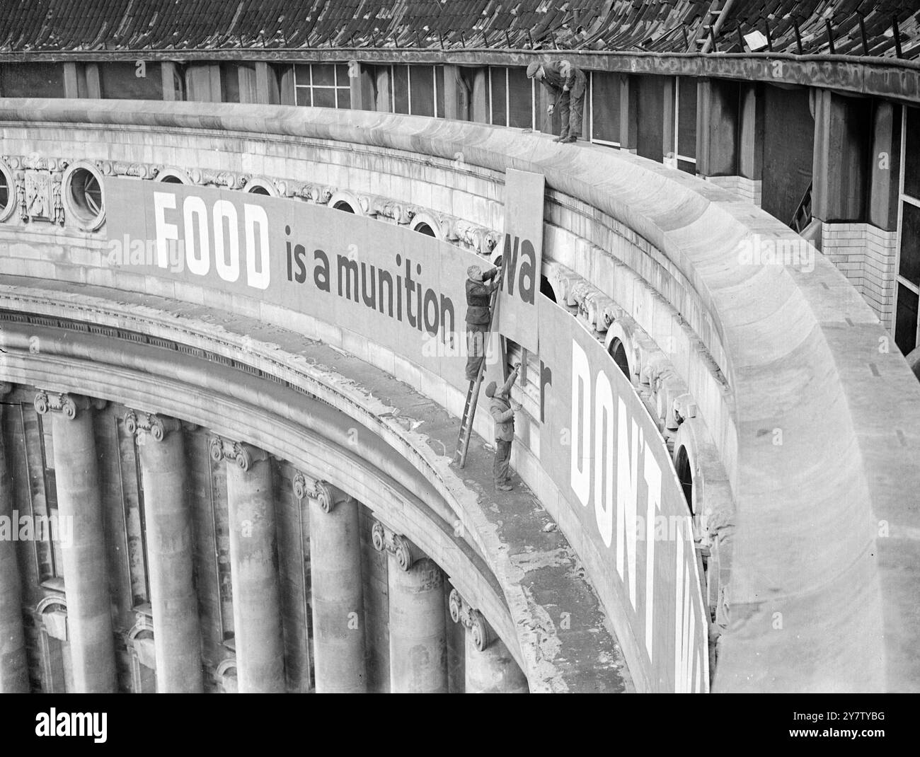 MINISTÈRE DE L'ALIMENTATION TROUVER UN NOUVEAU SLOGAN DE GUERRE dans le cadre de l'ouverture d'une grande nouvelle campagne contre le gaspillage alimentaire par le Ministère de l'alimentation, un nouveau slogan a été trouvé : ' la nourriture est une munition de guerre. Ne le gaspille pas ! Le slogan sera transformé en le plus grand signe jamais construit pour être embrasé à travers la célèbre façade riveraine de County Hall, Westminster. Photo montre : le panneau étant installé par des hommes au County Hall. 8 février 1941 Banque D'Images