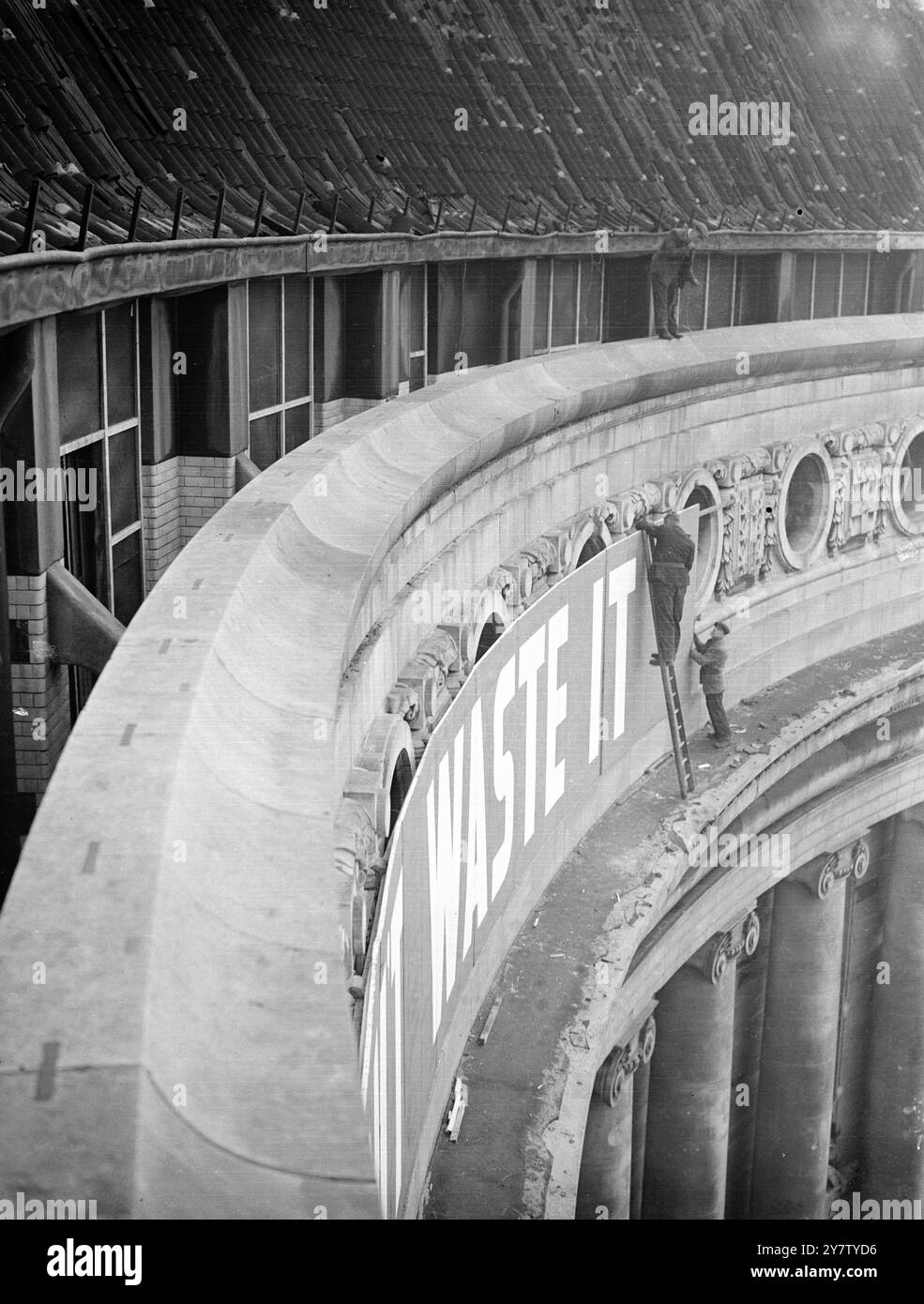 MINISTÈRE DE L'ALIMENTATION TROUVER UN NOUVEAU SLOGAN DE GUERRE dans le cadre de l'ouverture d'une grande nouvelle campagne contre le gaspillage alimentaire par le Ministère de l'alimentation, un nouveau slogan a été trouvé : ' la nourriture est une munition de guerre. Ne le gaspille pas ! Le slogan sera transformé en la plus grande enseigne construite pour être embrasée à travers la célèbre façade riveraine de County Hall, Westminster. Photo montre : le panneau étant installé par des hommes au County Hall. 8 février 1941 Banque D'Images