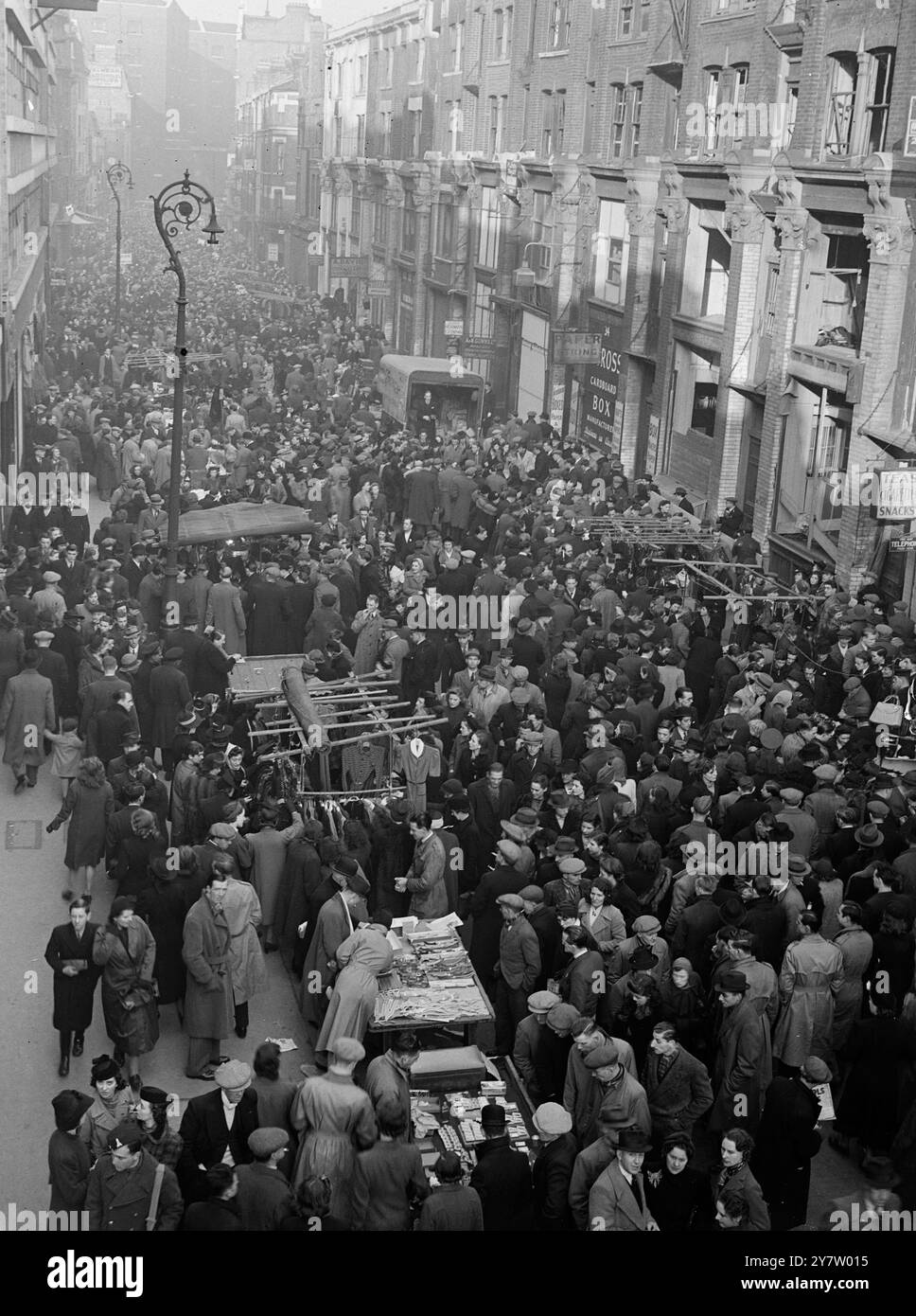 PETTICOAT LANE CONTINUE - avec l'approche du célèbre marché dominical de noël à Petticoat Lane, Middlesex Street, East London, bat son plein. - - Spectacles de photos : la foule dense de Petticoat Lane cherche des affaires de Noël parmi les nombreux commerçants de rue. - - 8 décembre 1940 Banque D'Images