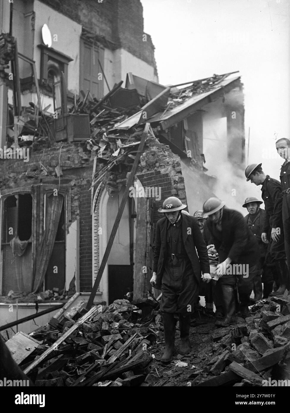 MAISONS ENDOMMAGÉES LORS DE RAIDS NOCTURNES SUR LA RÉGION DE LONDRES. Des maisons ont été endommagées lors de raids nocturnes sur la région de londres lorsque des bombes ont été larguées par des raids allemands. (Walworth Road) photos : membres d'un groupe de brancards emportant l'une des victimes. 9 décembre 1940 Banque D'Images