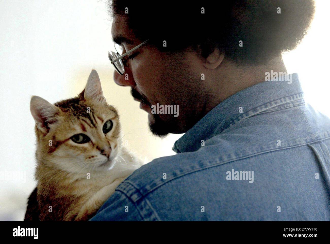 San Francisco, Californie --le client de PAWS Carl Stokes, de San Francisco, Calif., embrasse son chat Mr. Gingee à son appartement le dimanche 29 juin 2002. Les San Franciscains se sont réunis pour créer PAWS (Pets are Wonderful support) en 1986 pour aider les personnes à faible revenu vivant avec le SIDA et d'autres maladies invalidantes à garder leurs compagnons de compagnie. (RM pour usage éditorial uniquement - histoires d'affranchissement uniquement) Banque D'Images