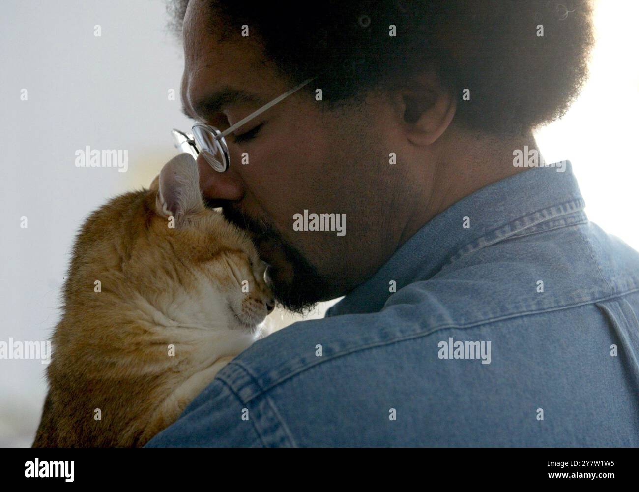 San Francisco, Californie --le client de PAWS Carl Stokes, de San Francisco, Calif., embrasse son chat Mr. Gingee à son appartement le dimanche 29 juin 2002. Les San Franciscains se sont réunis pour créer PAWS (Pets are Wonderful support) en 1986 pour aider les personnes à faible revenu vivant avec le SIDA et d'autres maladies invalidantes à garder leurs compagnons de compagnie. (RM pour usage éditorial uniquement - histoires d'affranchissement uniquement) Banque D'Images
