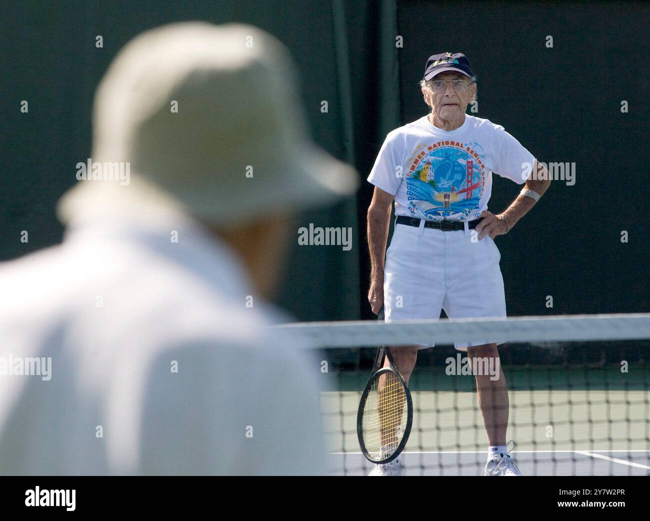 Stanford, Californie ,--Roger gentilhomme, 100 ans de New Bedford, ma, retourne la balle à James Kales, 94 ans de Bonita Springs, FL, le mardi 11 août 2009 hommes plus de 90 matchs de tennis en simple aux Jeux nationaux seniors d'été 2009 au Taube Family Tennis Stadium de l'Université Stanford. Roger gentilhomme est le plus vieux compétiteur dans les matchs Senior et participera au tennis le matin et au bowling l'après-midi. Banque D'Images