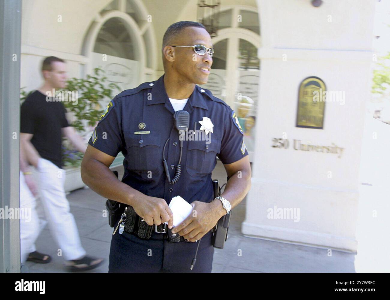 Palo Alto, Calif.,--L'agent de police de Palo Alto Curtiss Jackson, garde un œil sur les citzens qui accomplissent des actes de gentillesse dans les rues enclavées du centre-ville de Palo Alto le jeudi 31 mai 2001. La police de Palo Alto récompense les bons conducteurs et les piétons avec des coupons pour des produits gratuits allant d'une tasse de café à des repas au restaurant. Les officiels espèrent que le programme portera ses fruits avec des rues plus sûres selon les statistiques compilées par la California Highway Patrol. Banque D'Images