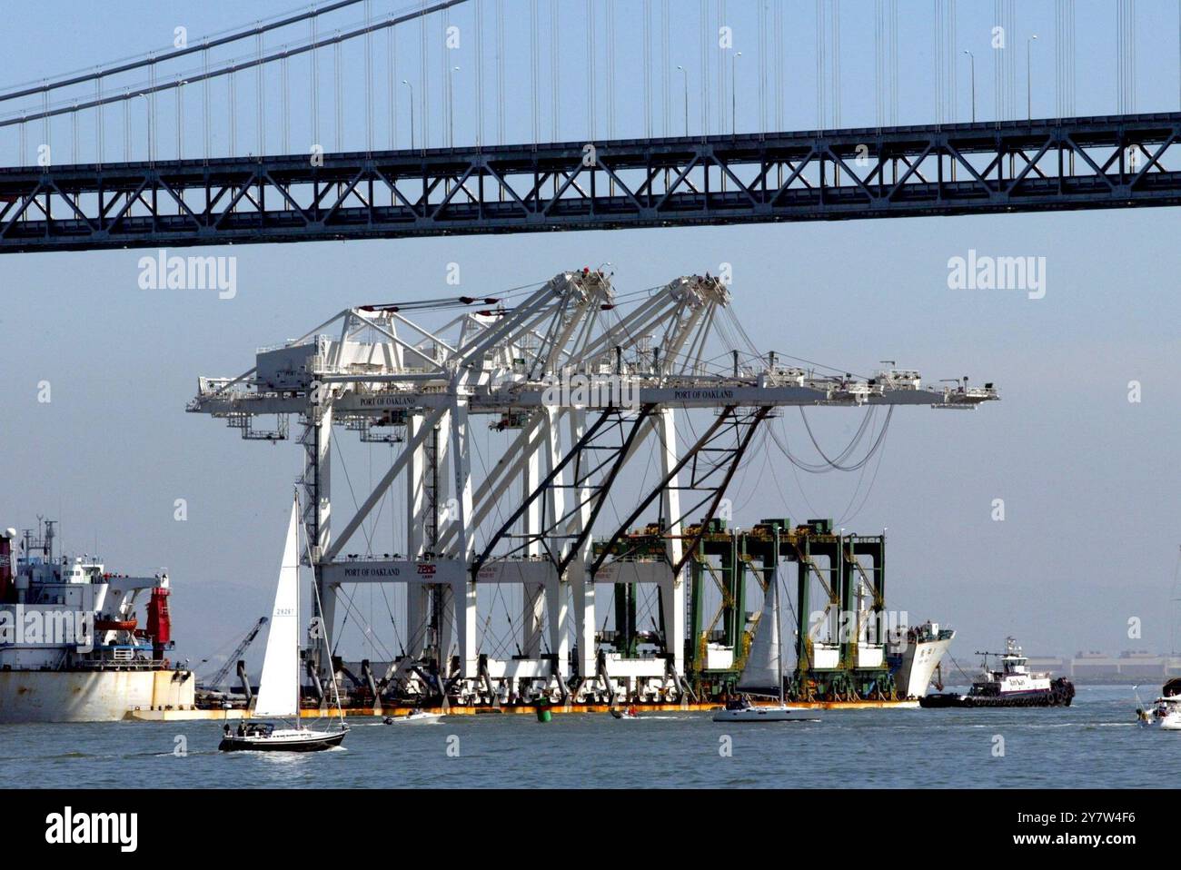 San Francisco, Californie.,-- les deux grues à conteneurs géantes du port d'Oakland s'insèrent juste sous le Bay Bridge alors qu'elles se rendaient au port d'Oakland le 5 mars 2005. Les grues mesurent 241 pieds de haut et ont été abaissées à 210 pieds pour s'adapter sous les ponts du Golden Gate et de la baie. Les deux nouvelles grues seront les plus hautes du Port. Banque D'Images