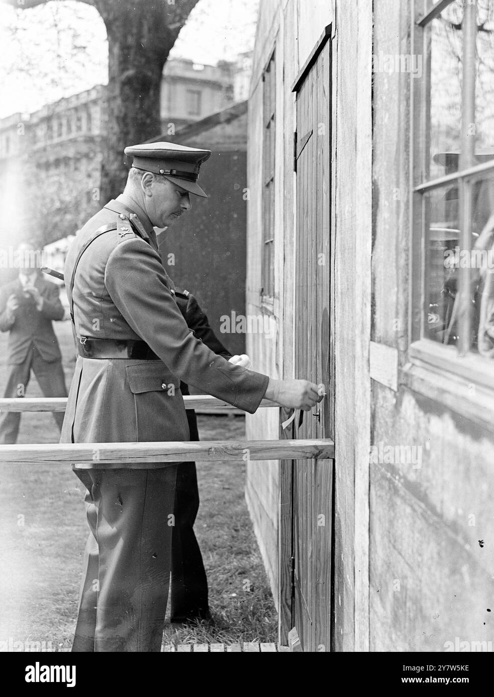 LE DUC DE GLOUCESTER OUVRE L'EXPOSITION DES PRISONNIERS DE GUERRE spectacles de photos : après l'ouverture de l'exposition des prisonniers de guerre, qui se compose d'un Stalag modèle, avec des gardes 'allemands' en uniforme, le duc de Gloucester ouvre la porte de l'une des cabanes. Les recettes de l'exposition, qui se tient à Clarence House, Londres par permisssion of the King, iront au fonds des prisonniers de guerre de la Croix-Rouge. 1er mai 1944 Banque D'Images