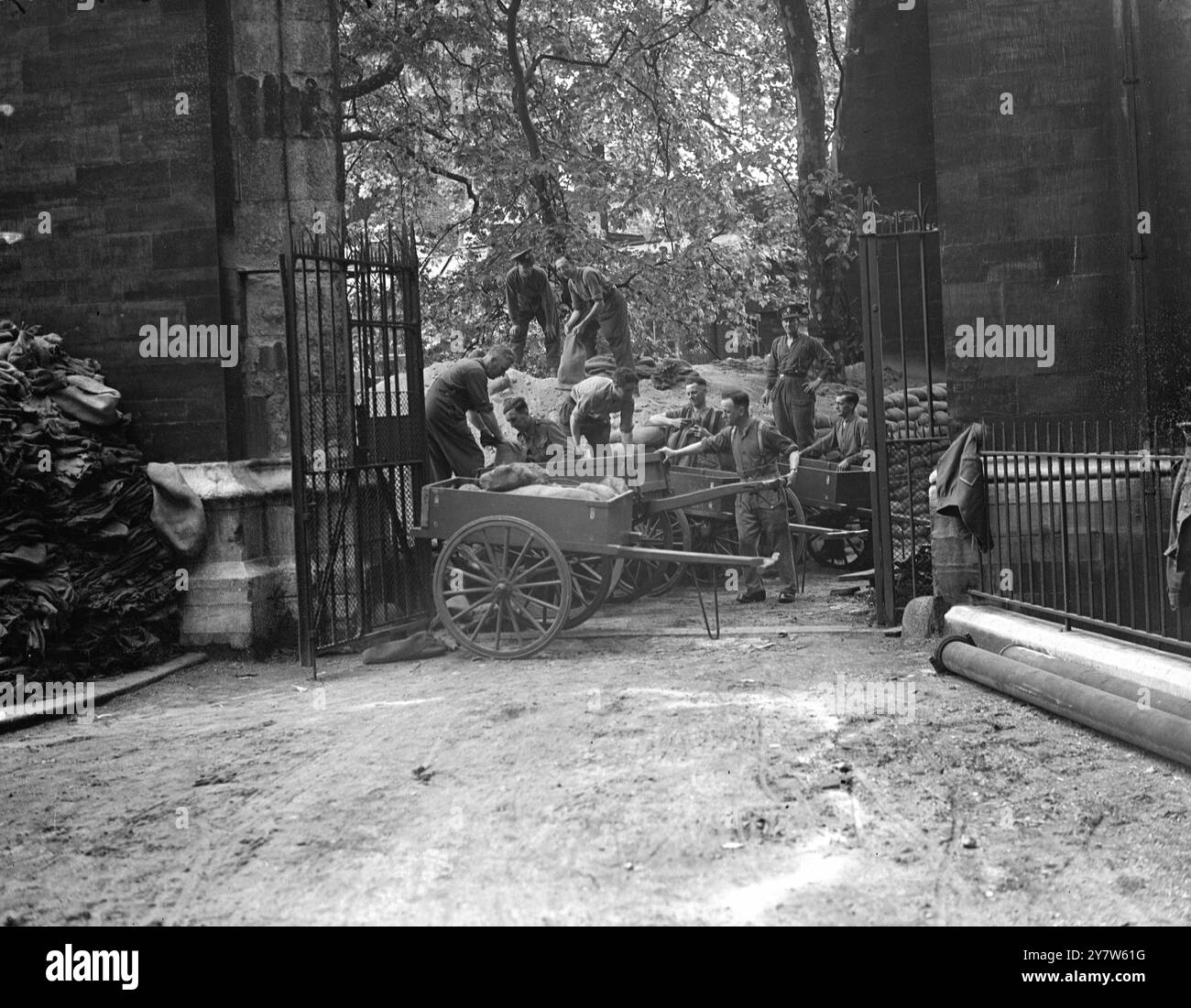 LONDRES GUÉRIT SES CICATRICES : LE TRAVAIL COMMENCE SUR L'ABBAYE DE WESTMINSTER le travail a commencé sur l'enlèvement de 80 000 sacs de sable qui protégeaient les monuments précieux de l'abbaye de Westminster, Londres et il est espéré que dans douze mois l'abbaye sera restaurée à son ancienne gloire. Les dégâts des raids aériens sont estimés à £135 000 mais des précautions efficaces contre les actions ennemies ont sauvé toutes les caractéristiques d'intérêt historique. Les vitraux les plus anciens ont été enlevés au début de la guerre, et le reste n'a pas été beaucoup endommagé, ils comprennent la maison du doyen, les cloîtres et les petits cloîtres et les bâtiments de l'école de Westminster et Banque D'Images