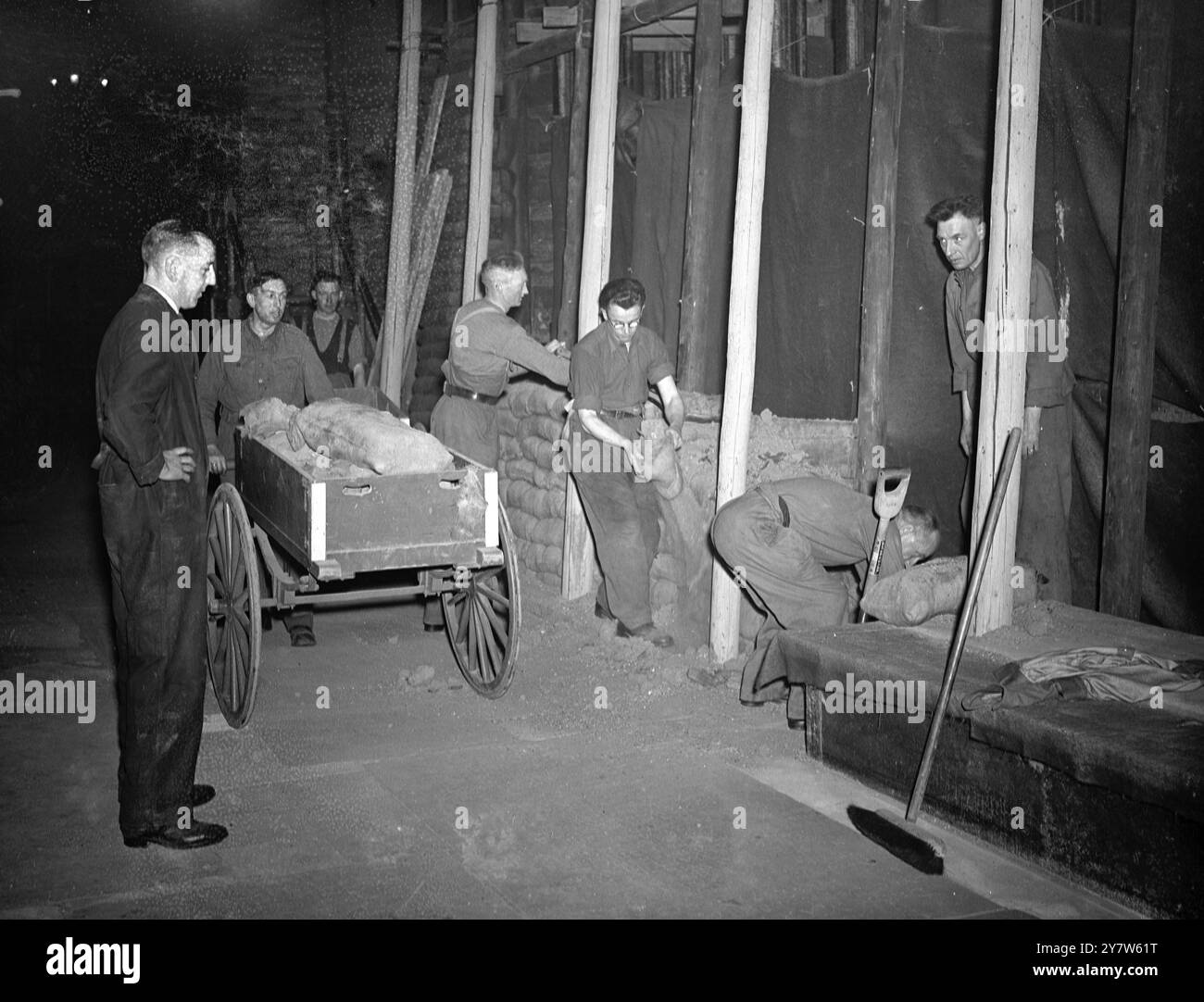 LONDRES GUÉRIT SES CICATRICES : LE TRAVAIL COMMENCE SUR L'ABBAYE DE WESTMINSTER le travail a commencé sur l'enlèvement de 80 000 sacs de sable qui protégeaient les monuments précieux de l'abbaye de Westminster, Londres et il est espéré que dans douze mois l'abbaye sera restaurée à son ancienne gloire. Les dégâts des raids aériens sont estimés à 135 000 £ mais des précautions efficaces contre les actions ennemies ont sauvé chaque caractéristique d'intérêt historique. Les vitraux les plus anciens ont été enlevés au début de la guerre, et le reste n'a pas été beaucoup endommagé, ils comprennent la maison du doyen, les cloîtres et les petits cloîtres et les bâtiments de l'école de Westminster an Banque D'Images