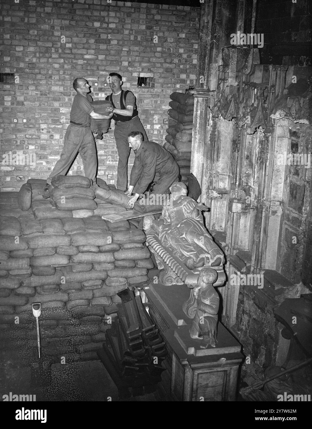 LONDRES GUÉRIT SES CICATRICES : LE TRAVAIL COMMENCE SUR L'ABBAYE DE WESTMINSTER le travail a commencé sur l'enlèvement de 80 000 sacs de sable qui protégeaient les monuments précieux de l'abbaye de Westminster, Londres et il est espéré que dans douze mois l'abbaye sera restaurée à son ancienne gloire. Les dégâts des raids aériens sont estimés à 135 000 £ mais des précautions efficaces contre les actions ennemies ont sauvé chaque caractéristique d'intérêt historique. Les vitraux les plus anciens ont été enlevés au début de la guerre, et le reste n'a pas été beaucoup endommagé, ils comprennent la maison du doyen, les cloîtres et les petits cloîtres et les bâtiments de l'école de Westminster an Banque D'Images