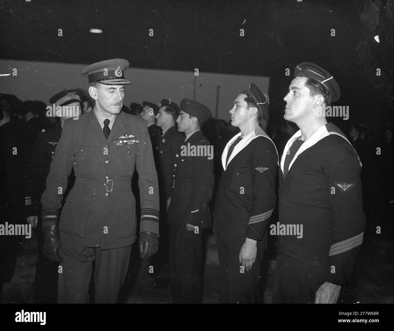 LES AVIATEURS FRANÇAIS FORMÉS EN GRANDE-BRETAGNE REÇOIVENT LEURS AILES dans une station de la RAF en Grande-Bretagne les cadets français qui ont été formés dans ce pays reçoivent leurs ailes du vice-maréchal de l'Air Champion deCrespigny, qui était un pilote de chasse opérant avec les Français dans la dernière guerre. Plusieurs des cadets s'étaient échappés de France depuis le jour J et retourneront dans leur pays libéré en tant que pilotes entraînés. Photo montre : le vice-maréchal de l'air Champion de Crespigny inspectant les cadets français avant de leur présenter leurs ailes. Aviateurs de la marine parmi les pilotes entraînés 28 février 1945 Banque D'Images