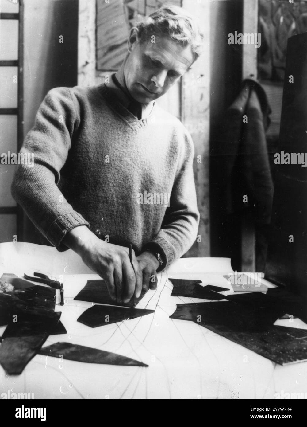 Vitraux pour la cathédrale de Coventry - Laurence Lee, la directrice des travaux, coupe des vitraux sur une ligne de découpe illuminée à grande échelle. Il est l’un des trois co-concepteurs des fenêtres. - 8 septembre 1955 Banque D'Images