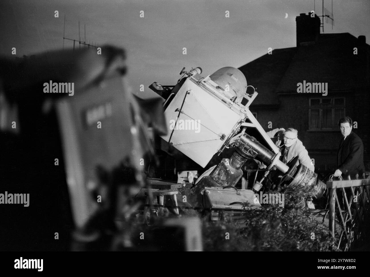 George Hole, l'un des astronomes les plus connus de Grande-Bretagne, photographié avec un télescope qu'il s'est fait gréer dans le jardin arrière de sa maison à Patcham, Sussex, Angleterre. Alors que le monde regarde le premier homme sur la lune à la télévision, M. Hole espère apercevoir les fusées éclairantes alors que le module lunaire d'Apollo XI descend à la surface de la lune à la mer de tranquillité. La lune peut être vue à côté de la cheminée de Mr. Holes House.21 juillet 1969 Banque D'Images