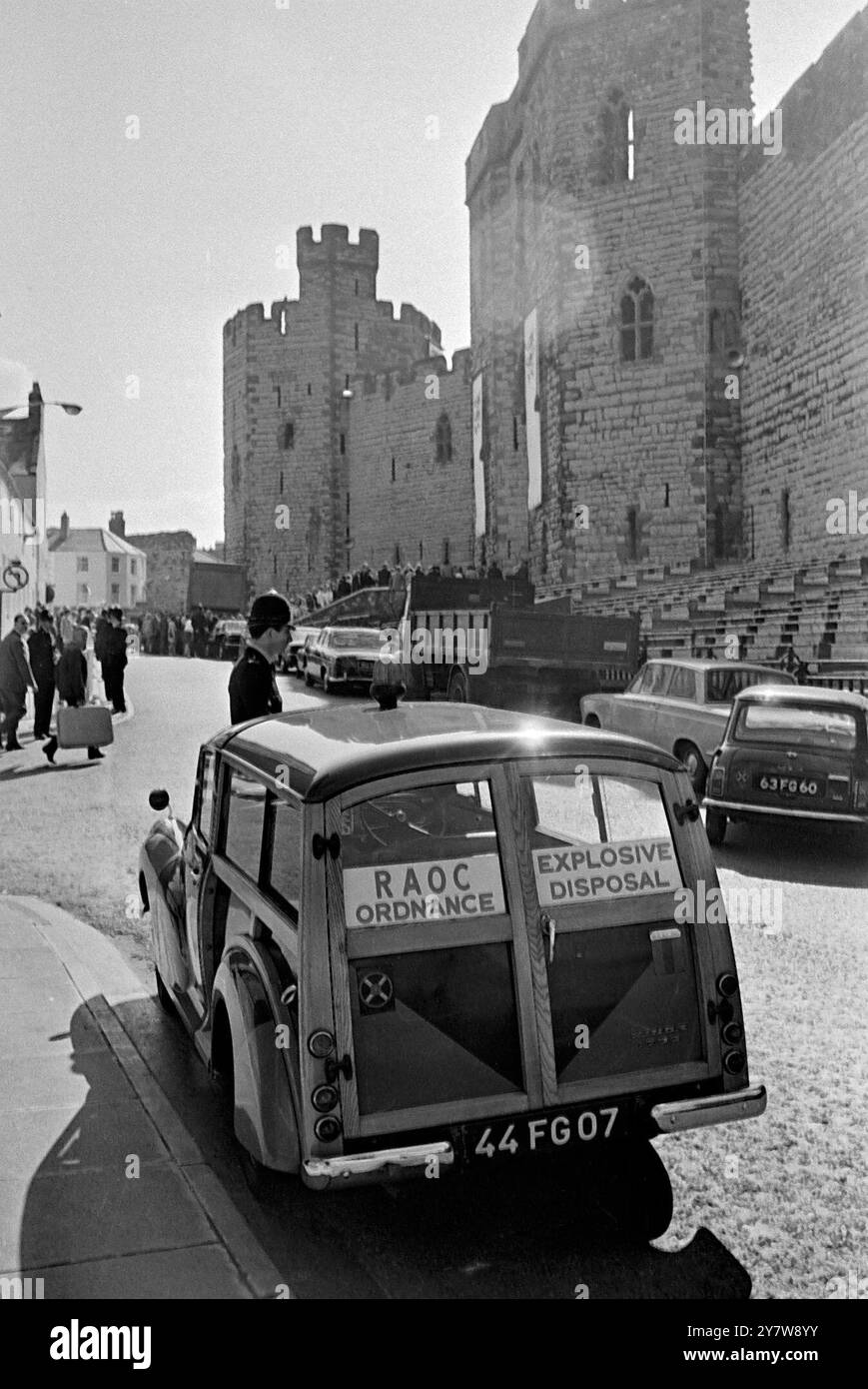 Un officier de l'escouade d'élimination des bombes quitte King's Gate, Château de Caernarvon en début d'après-midi avec des officiers du CID après avoir effectué une recherche à l'intérieur du Château avant le début de l'investiture du Prince Charles en tant que Prince de Galles. - La cérémonie a été exécutée par la mère du Prince de 20 ans, la reine Elizabeth III - 1er juillet 1969 Banque D'Images