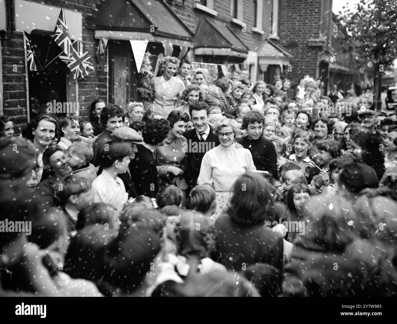 Nicky Gargano, 20 ans, qui a remporté le championnat des poids lourds lors des combats pour le titre européen à Berlin, est accueilli et entouré d'admirateurs à son arrivée chez lui à Monier Road, Bow, Londres. Gargano, détenteur du titre de la British amateur Boxing Association, bat Hippolyte Annexe de France aux points lors de la finale du tournoi européen.6 juin 1955 Banque D'Images