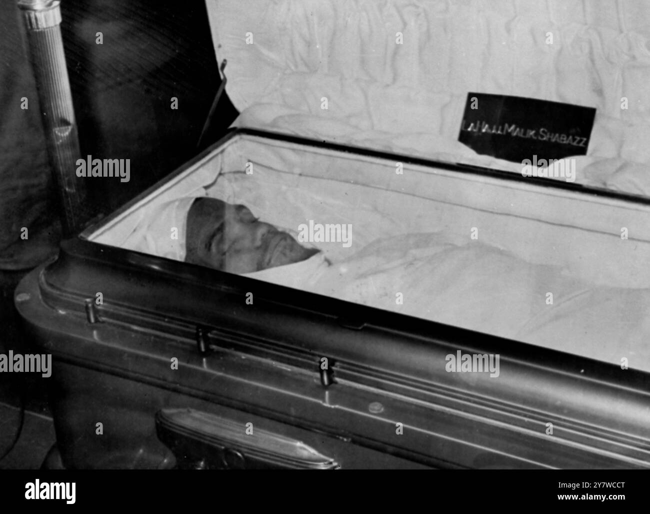 Malcolm X Burial ServiceNew York : Malcolm X , abattu lors d'une réunion dimanche dernier , repose dans son cercueil à la Maison funéraire Unity ici hier avec seulement son visage visible dans le drap funéraire blanc musulman appelé un Kafan . Son corps a été enveloppé dans le Kafan lors d'une brève cérémonie par le cheikh Ahmed Hassoun , membre des musulmans sunnites , que l'extrémiste mort a rencontré lors d'une visite en extrême-Orient l'année dernière . Hassoun est venu à Amrica pour enseigner les principes de la religion musulmane aux disciples de Malcolm X . Les funérailles auront lieu aujourd'hui 27 février 1965 Banque D'Images