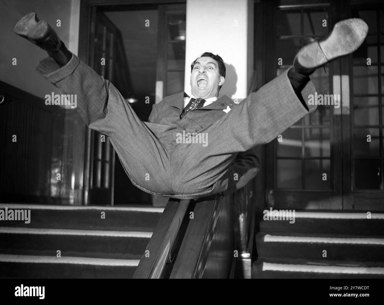 Entrée peu orthodoxe au show business britannique par le comédien américain Danny Thomas , vu faire un acte rapide sur un rail d'escalier au Prince of Wales Theatre , Londres , Angleterre aujourd'hui . Thomas vient d'arriver à Londres pour apparaître au palladium lorsqu'il reviendra à Variety lundi prochain 27 mars 1950 . Maintenant classé par ses admirateurs comme un artiste aussi doué que Danny Kaye , Al Jolson et Maurice Chevalier , Danny Thomas ( son vrai nom est Amos Jahoob ) est né à Tolède , USA , l'un des 10 enfants d'un candymaker syrien . On estime qu'il gagnait jusqu'à £2000 par semaine dans un cabaret américain. Banque D'Images