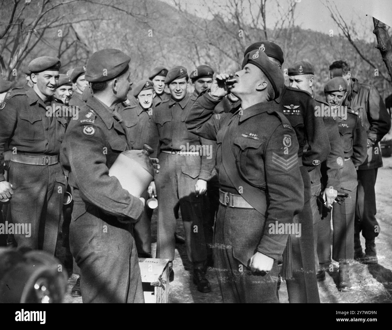 Canadian ' Splice the Mainbrace ' en Corée les troupes canadiennes du Princess Pat's Regiment , actuellement en service en Corée , ont reçu l'aide de grog , après la cérémonie de réception du drapeau des Nations Unies . Photos : le Sgt William Sius de Calgary, Alberta , descend son grog à la cérémonie de « raccordement du mainbrace » en Corée. 18 janvier 1951 Banque D'Images