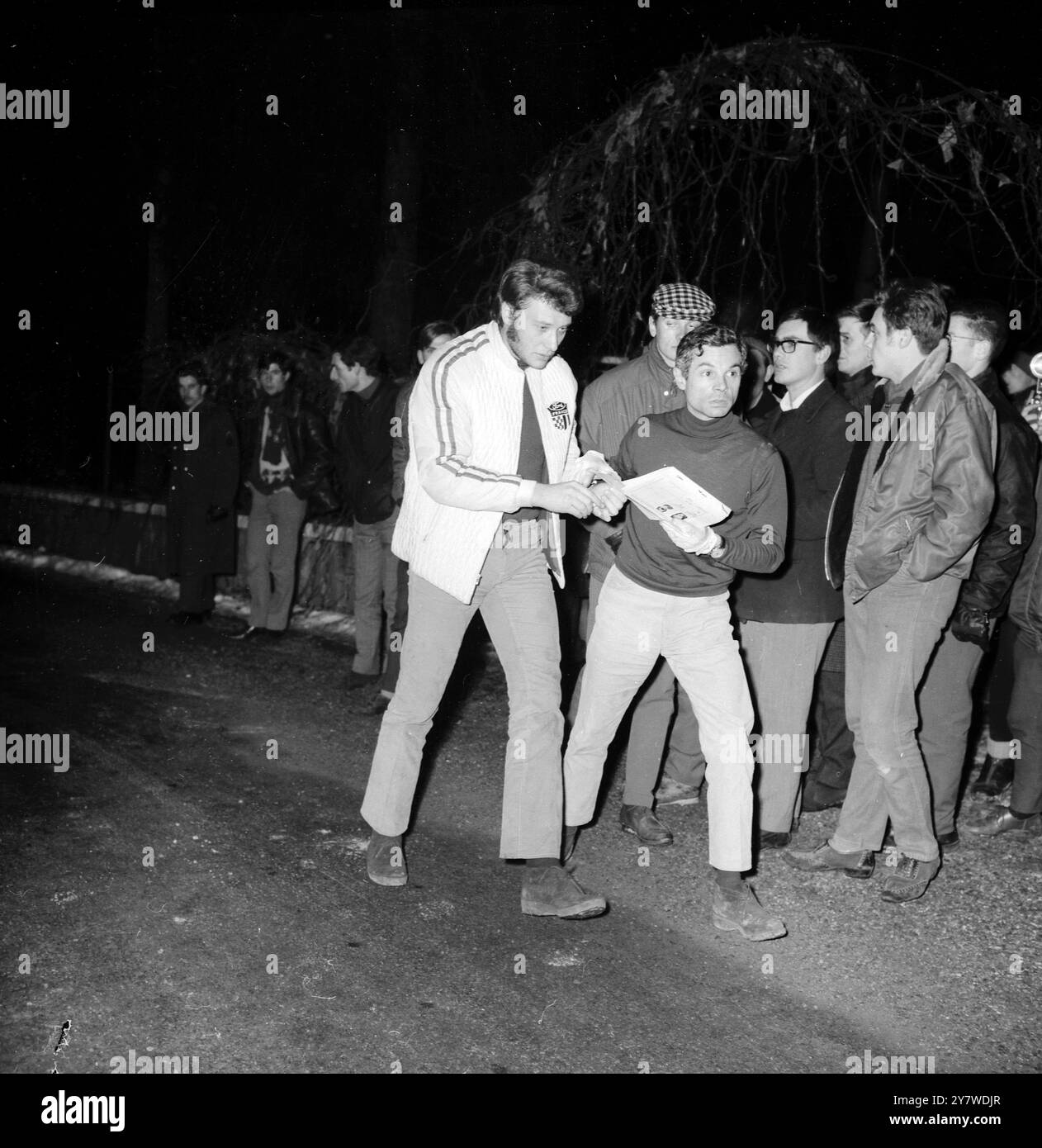 Grenoble , lors de la Monaco -Chambéry - Monaco Alpine Night - tour du Rallye de Monte Carlo populaire chanteur pop français Johnny Hallyday ( au centre ) a dû signer l'égister de rallye au Col de Fence - il a été assiégé par des fans admirateurs pour son autographe le 20 janvier 1967 Banque D'Images