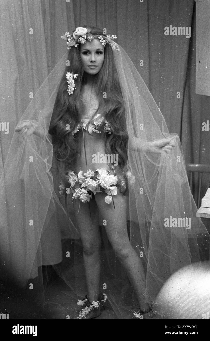 Hippy - robe de mariée inspirée. Cette robe de mariée a été présentée dans la collection printemps et été 1968 du designer parisien Yves Saint-Laurent. Les fleurs décorent les pieds, la ligne de hanche et la ligne de buste. Accessoires : voile léger et cheveux aux hanches le 30 janvier 1968 Banque D'Images