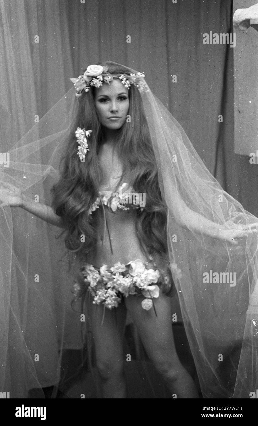 Hippy - robe de mariée inspirée. Cette robe de mariée a été présentée dans la collection printemps et été 1968 du designer parisien Yves Saint-Laurent. Les fleurs décorent les pieds, la ligne de hanche et la ligne de buste. Accessoires : voile léger et cheveux aux hanches le 30 janvier 1968 Banque D'Images