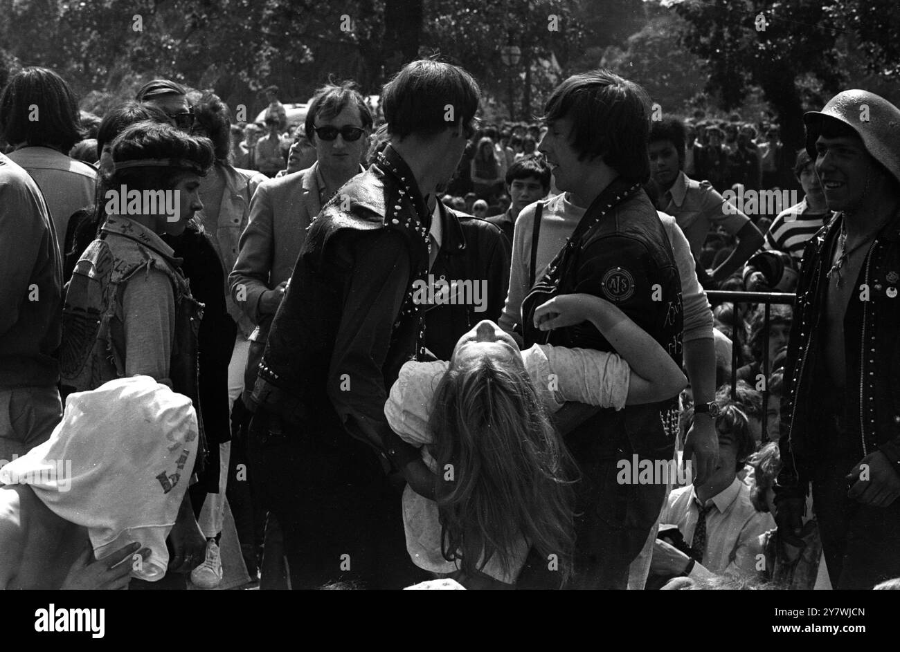 Une fille fan qui s'est évanouie lors du concert ' come - back ' en plein air des Rolling Stones , est emportée par deux membres des ' Hells Angels ' , qui étaient présents au concert pour protéger le groupe et contrôler les fans . Londres Hyde Park . 6 juillet 1969 Banque D'Images