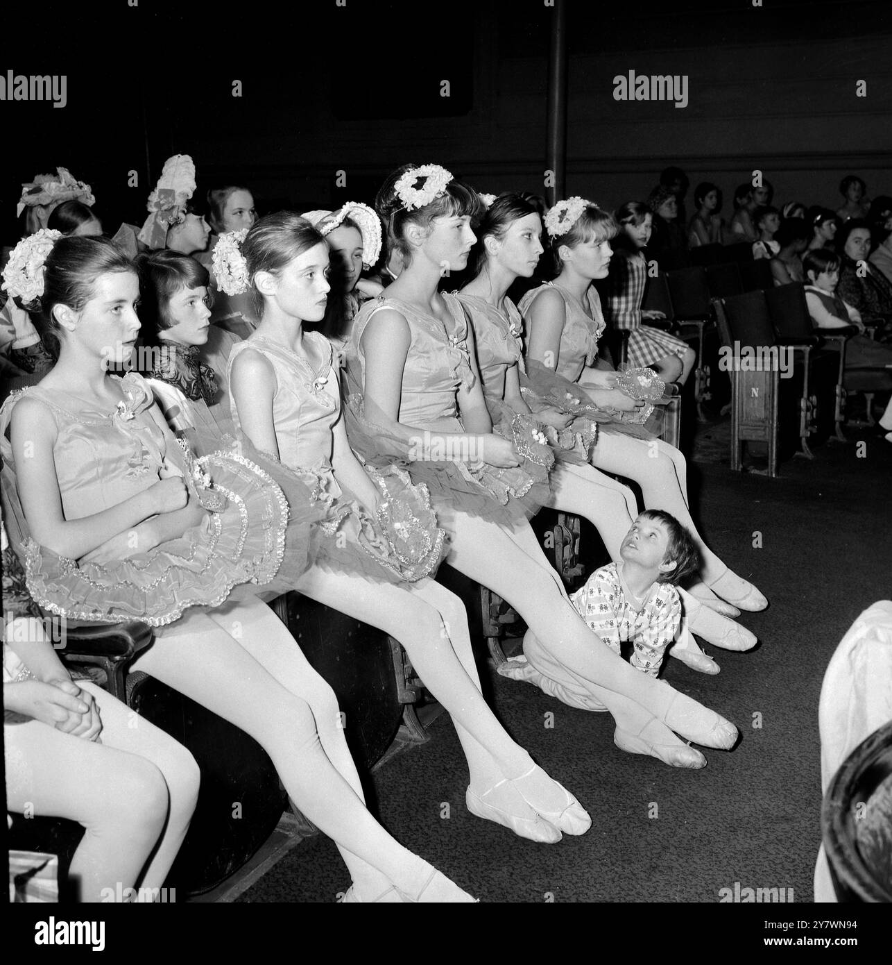 Répétition de la matinée des enfants airs et grâces au Scala Theatre de Londres, Tracey Griffith, 4 ans de l'Anthorne School of Dancing , Potters Bar , qui dans cette partie de Wendy est la plus jeune danseuse du spectacle, jette un regard admiratif sur les danseurs plus âgés qui attendent leur tour pour monter sur scène . Plus de 300 enfants d'écoles de danse bien connues ont joué à l'aide de la charité. 2 décembre 1966 Banque D'Images