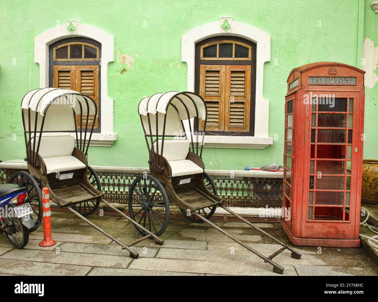 Trishaws et cabine téléphonique au Pinang Peranakan Mansion à Georgetown, Penang, Malaisie. Banque D'Images