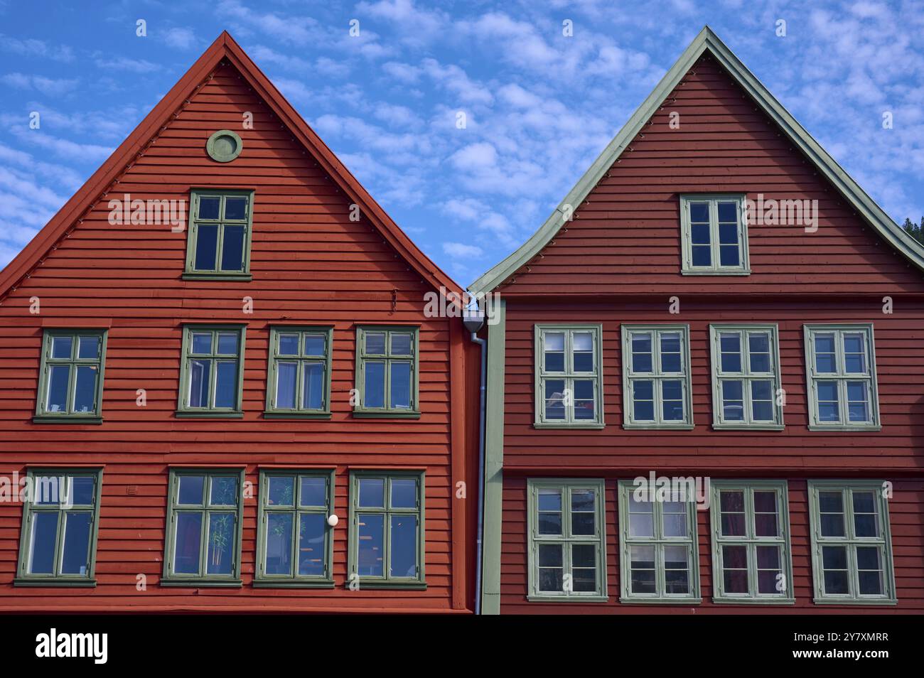 Maisons traditionnelles en bois rouge sous un ciel bleu avec des toits inclinés et de multiples fenêtres dans une vieille ville ensoleillée, Bryggen, Bergen, Vestland, Norvège, Europe Banque D'Images