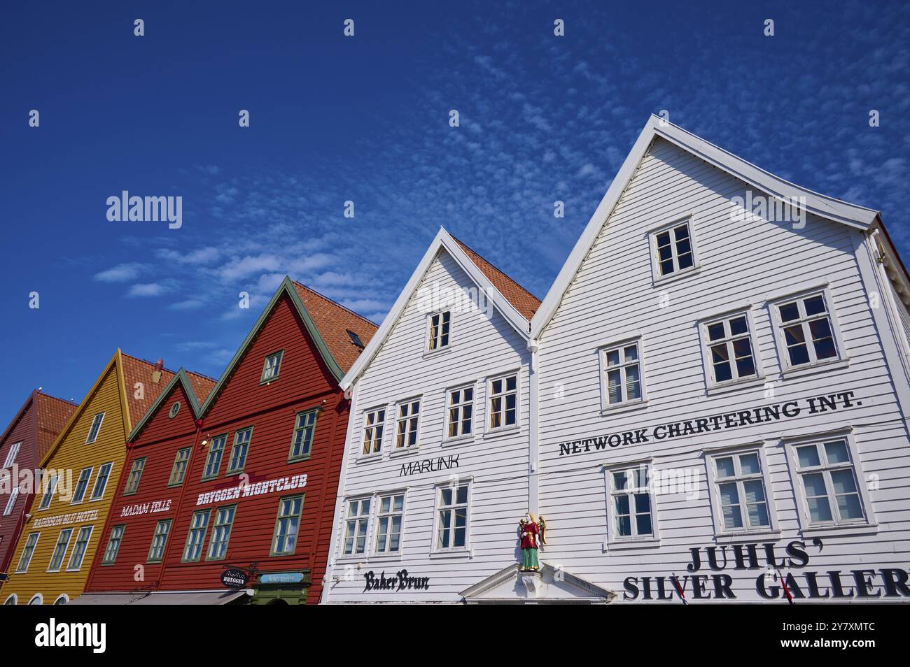 Maisons traditionnelles en bois sous un ciel bleu avec des toits inclinés et de multiples fenêtres dans une vieille ville ensoleillée, Bryggen, Bergen, Vestland, Norvège, Europe Banque D'Images