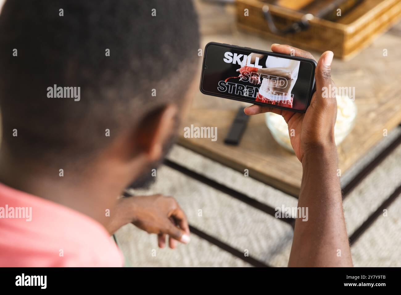 Regarder la vidéo de fitness sur smartphone, l'homme se concentrant sur la compétence, la vitesse, la force Banque D'Images