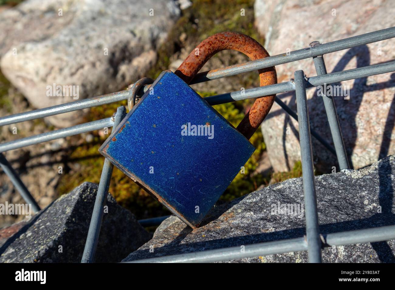 Un vieux cadenas rouillé lovelock attaché à la grille en acier Banque D'Images
