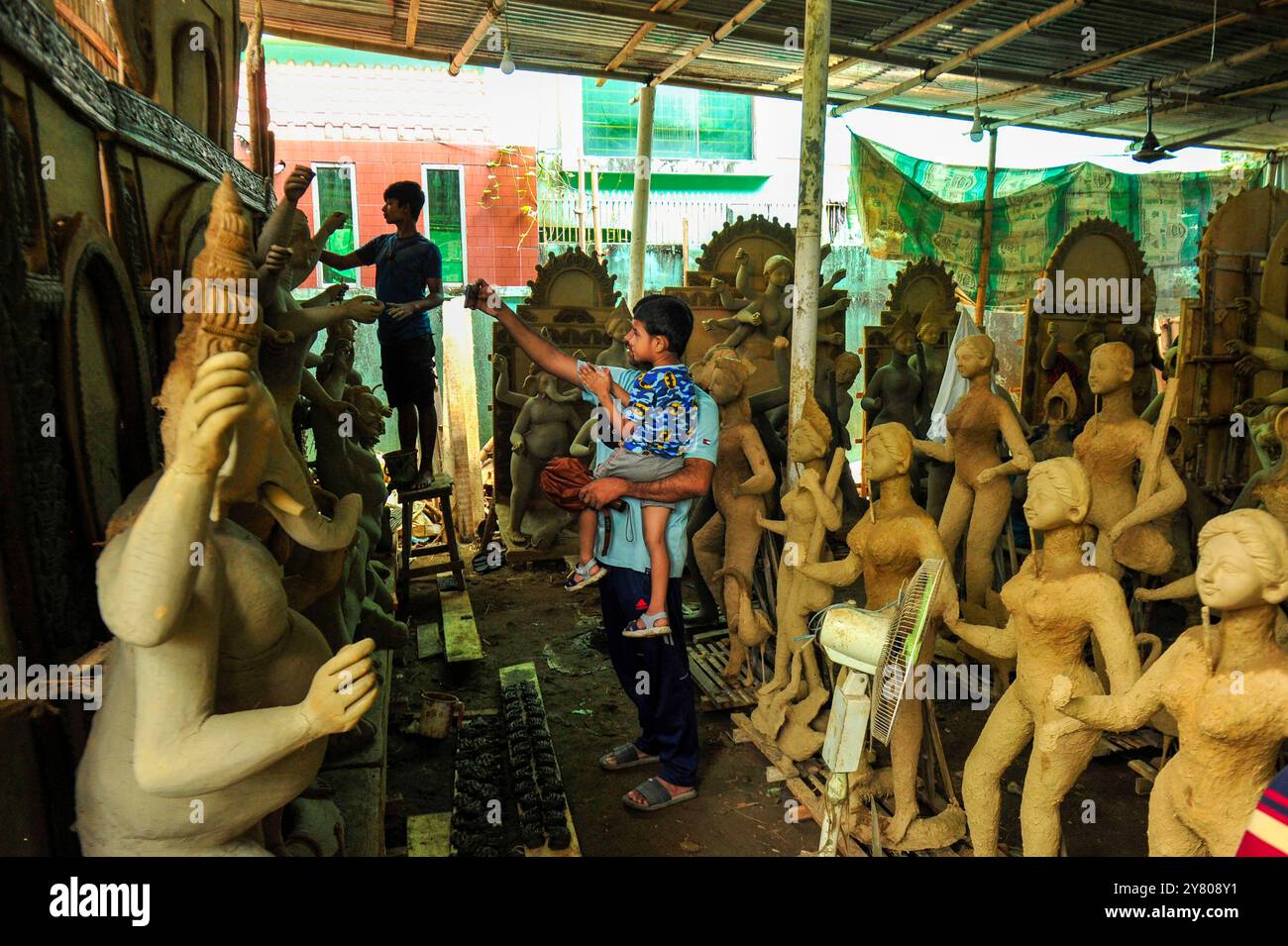 Les visiteurs prennent des selfies avec des idoles d’argile préparées pour le festival Durga Puja à Sylhet, au Bangladesh. Durga Puja est le festival religieux et culturel le plus important pour les hindous, célébré dans tout le Bangladesh avec beaucoup d'enthousiasme, des festivités vibrantes et une profonde dévotion religieuse. Banque D'Images